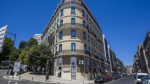 Un immeuble à plusieurs étages doté d’une façade incurvée, de nombreux balcons et d’une promenade piétonne.
