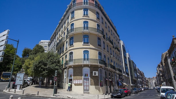 A multi-story building with a curved facade, multiple balconies, and a pedestrian walkway. - LxWay Apartments Largo de Santa Bárbara (Lisbon)