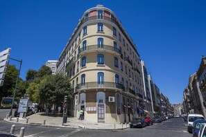 A multi-story building with a curved facade, multiple balconies, and a pedestrian walkway. - LxWay Apartments Largo de Santa Bárbara (Lisbon)
