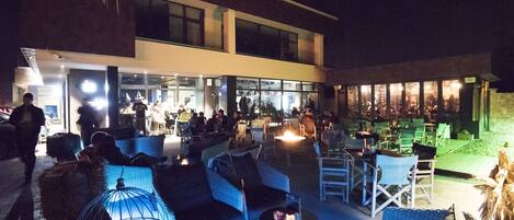 An outdoor seating area with wicker furniture and a glass enclosure.