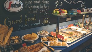 A buffet counter with various food items and a chalkboard with motivational messages. - Hotel Castellum (Cakovec)