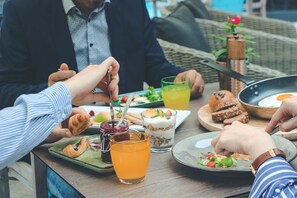 A dining table with various food items and drinks, including a croissant, a sandwich, and a glass of orange juice. - Hotel Castellum (Cakovec)