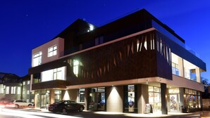 A modern building with a glass facade, large windows, and a well-lit entrance. - Hotel Castellum (Cakovec)
