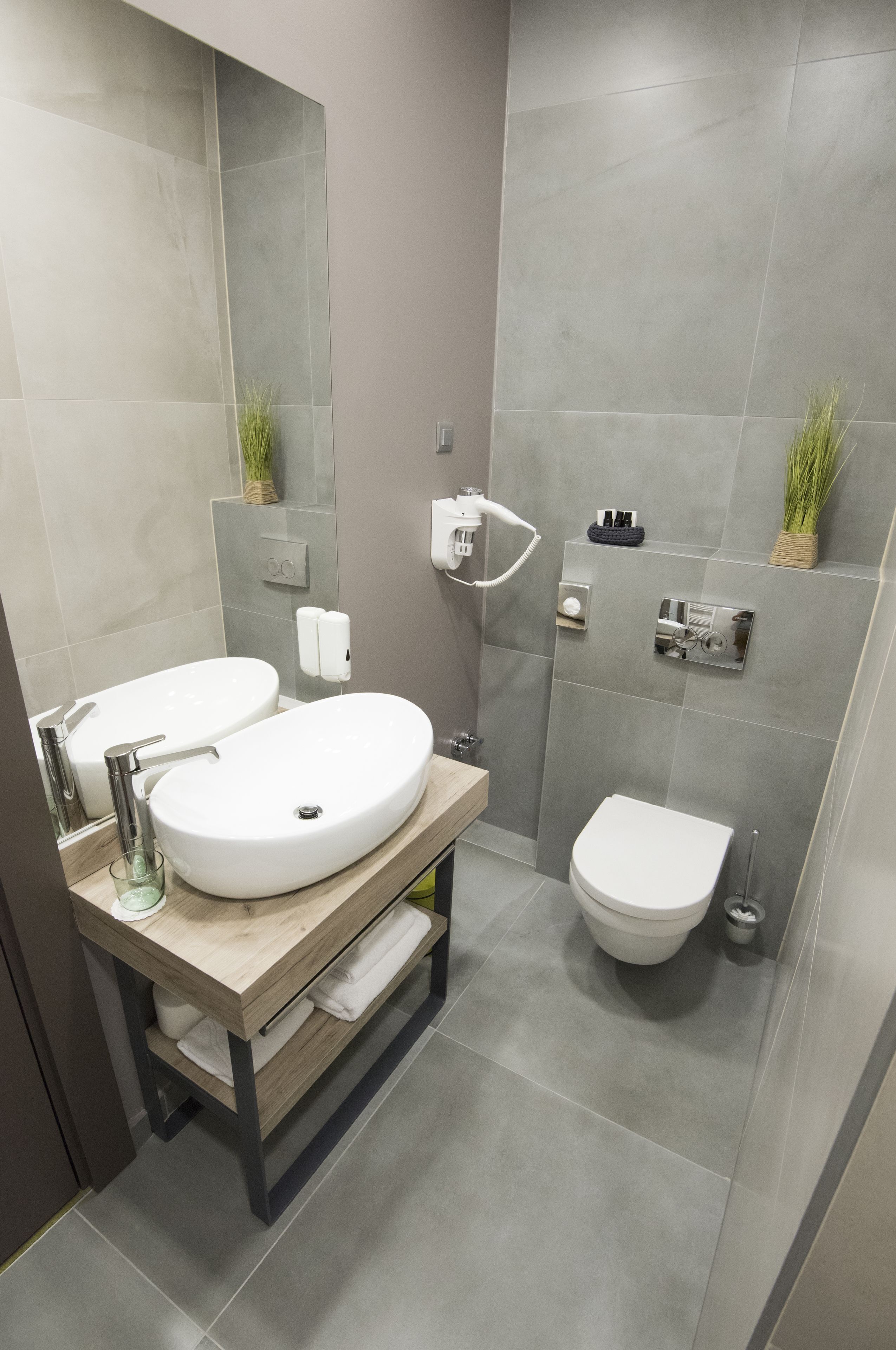 Et moderne badeværelse med dobbelt vask, toilet og bruseniche.