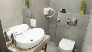 Et moderne badeværelse med dobbelt vask, toilet og bruseniche.