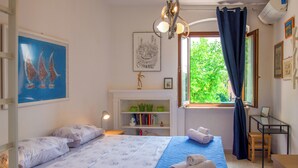 A bedroom with a bed, a desk, a bookshelf, and a window with curtains. - Verona up to you   Panorama with car & bike places (Verona)