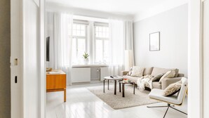 A modern living room with a sofa, coffee table, and a TV on a wooden cabinet.