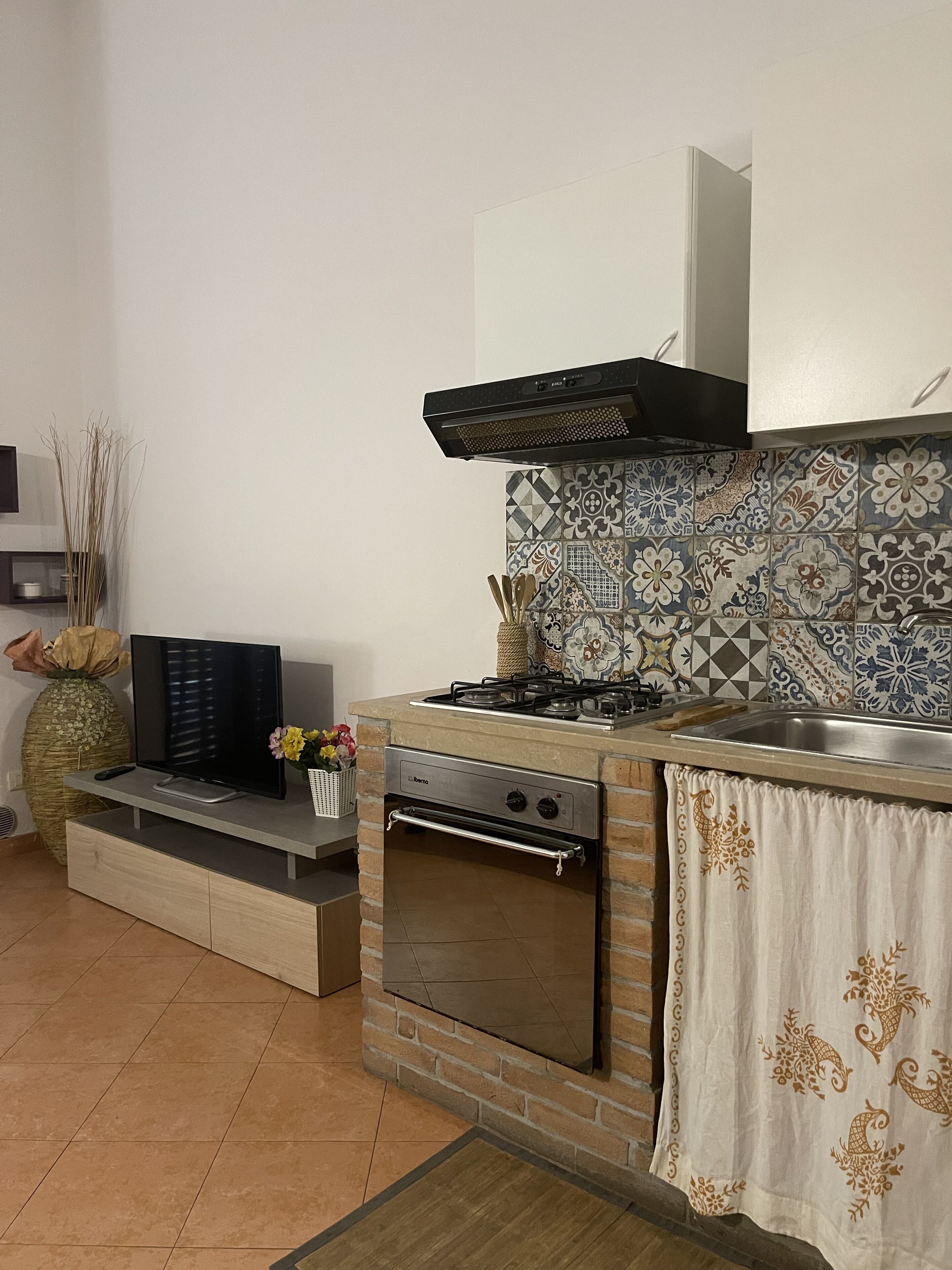 A kitchen with a gas stove, oven, and a tiled backsplash.