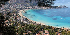 A coastal town with a beach, boats, and buildings along the shore. - Hola Cathedral House (Palermo)