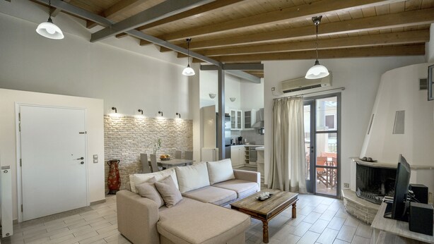 Een moderne woonkamer met een hoekbank, een houten salontafel en een open haard.