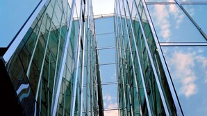 A modern glass building with a symmetrical facade and reflective glass panels. - Hotel Astoria (Lucerne)