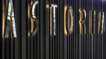 Una pared metálica con la palabra 'ASTORIA' iluminada en letras grandes.