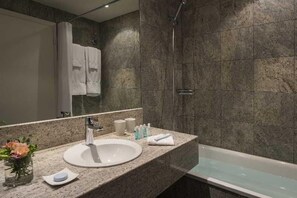 Une salle de bain avec un lavabo, un miroir et une douche.