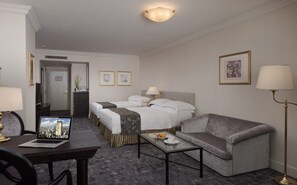 A hotel room with a bed, two bedside tables, a sofa, a desk with a laptop, and a floor lamp. - Hi Lai EZ Stay (Kaohsiung)