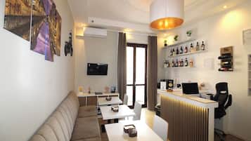 Eine moderne Hotelhalle mit einer Couch, Tischen, einer Rezeption und einem Fernseher.