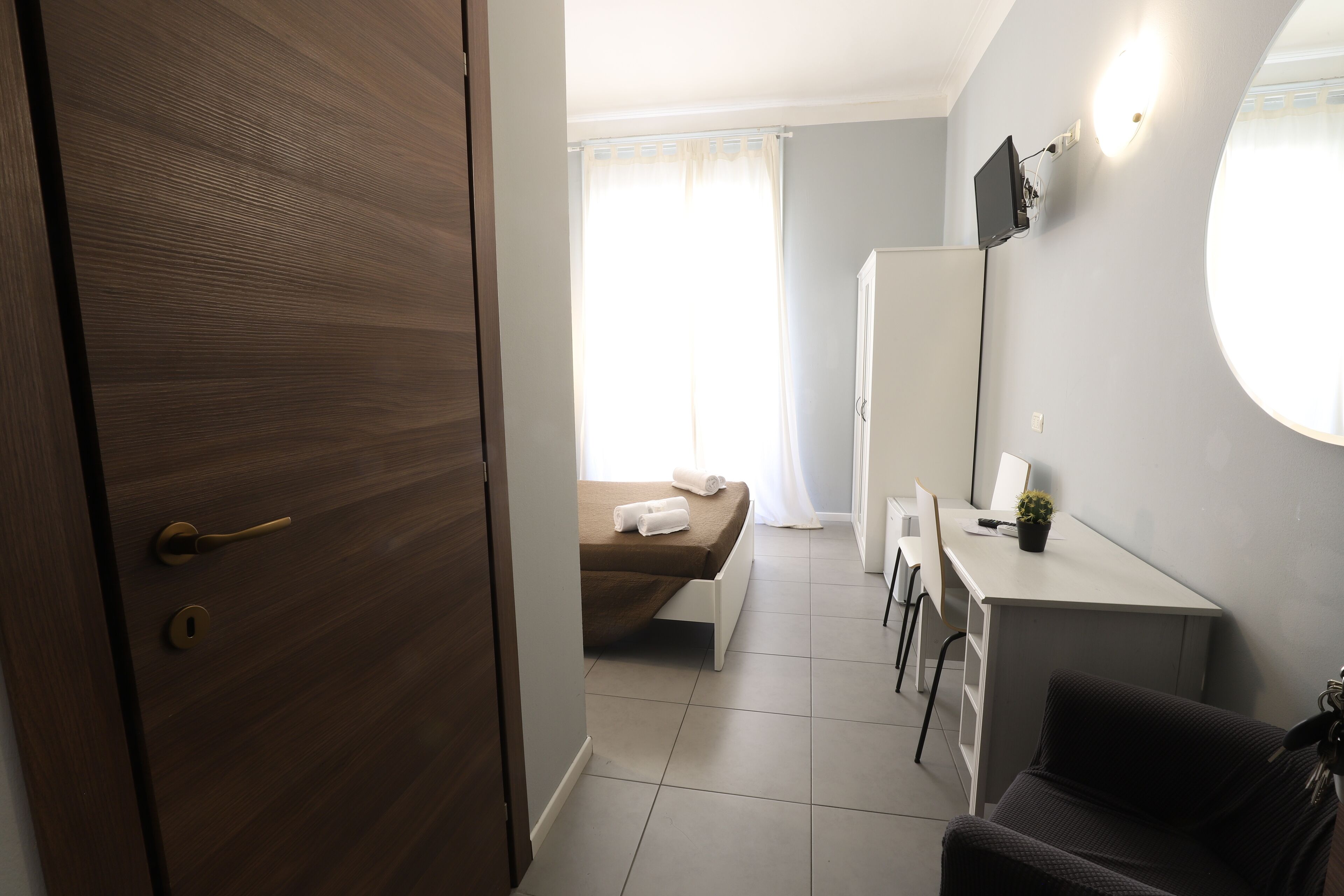 Quarto com cama, escrivaninha e cadeira.
