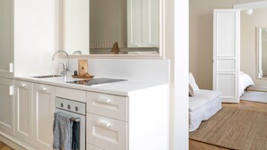 A modern, minimalist bathroom with a large mirror, white cabinetry, and a sink. - Roost Roobert (Helsinki)