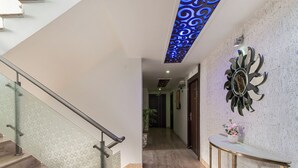 Interior moderno com escada, corredor e um detalhe decorativo na parede.