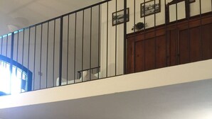 Une maison à deux étages avec un escalier en bois, un canapé et un meuble.