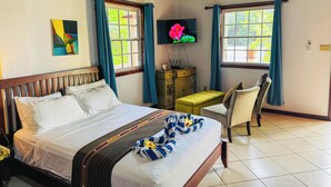 A hotel room with a bed, a desk, a chair, a TV, and two windows with curtains. - Studio Apartment In Hopkins (Hopkins)