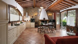 A spacious kitchen with wooden beams, a dining area, and a large window overlooking greenery. - Legnaia countryside luxury property, shared pool, ideal base to discover Tuscany (Siena)