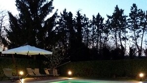 A swimming pool with lounge chairs and umbrellas, surrounded by trees. - Legnaia countryside luxury property, shared pool, ideal base to discover Tuscany (Siena)
