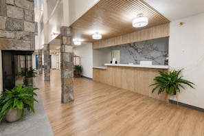 A spacious lobby with a reception desk, stone pillars, and potted plants. - ML 259 - Charming 2BR w/new deck. Ready for you to enjoy this summer! (Snowshoe)
