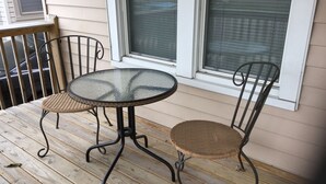 A small outdoor patio with a glass-top table and two wicker chairs. - Relaxing! Professionally Cleaned, Self Check In - Sleeps 12 (Racine)