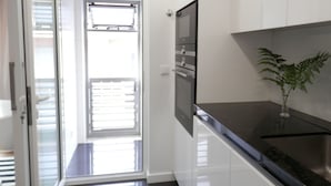 A modern kitchen with white cabinetry, a stainless steel refrigerator, and a potted plant. - Ripple - near Congress Centre & River- A/C, swimming, pool, secure parking (Lisboa)