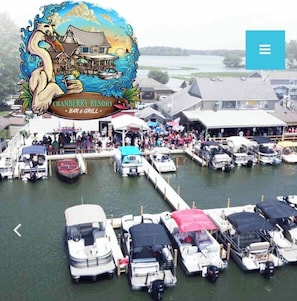 A marina with various boats docked, a crowd of people, and a building with a sign that reads "CRANBERRY RESORT BAR & GRILL." - ❤️ Waddle Inn ❤️ Luxury Cottage on Tecumseh Island (Huntsville)