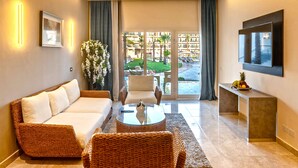 A modern living room with a sofa, chairs, a coffee table, and a TV.