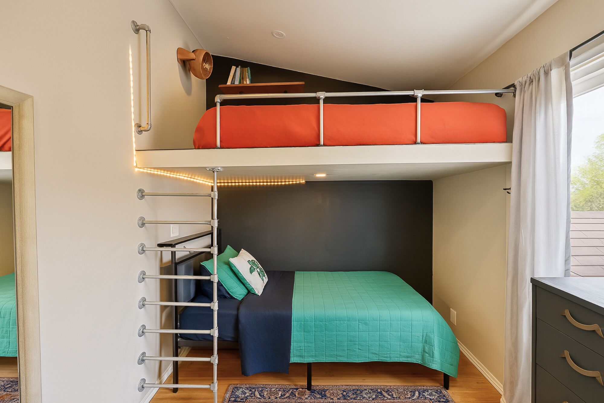 Dormitorio con literas, escritorio y ventana.