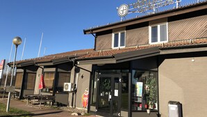 Un bâtiment sur lequel on peut lire l’inscription « VARDSHUSET GLACIA », et une zone de sièges extérieure abritée, dotée de bancs.