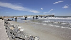 A pier extending into the ocean with a rocky shoreline and a clear sky. - Beachy Getaway–Cozy, Clean & Equipped w/ All Essentials! Relax, Enjoy & Refresh! (St Augustine Beach)