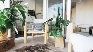 A modern living room with a sofa, a dining table, and potted plants. - Roost Lauttasaari (Helsinki)