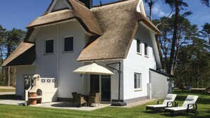 Una casa con un diseño arquitectónico único, que presenta un alero grande y una chimenea.