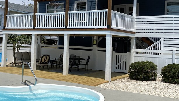 A two-story house with a covered patio, outdoor seating, and a swimming pool. - 4 Bed 3.5 Bath Pool Mid Island, Quiet Garden lined Street, steps from the Beach! (Ocean Isle Beach)