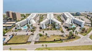 Un hotel con varias edificaciones, piscina y vistas al océano.