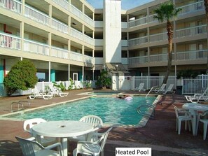 A hotel with a heated pool, multiple balconies, and outdoor seating areas. - Sands of time,VIEW 180°, PEACEFUL,360° VIDEO,WIFI, CABLE,ROKU,DVDS, FALL CHEAPER (Corpus Christi)