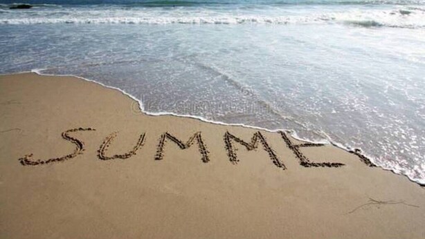 Una playa con la palabra "VERANO" escrita en la arena.