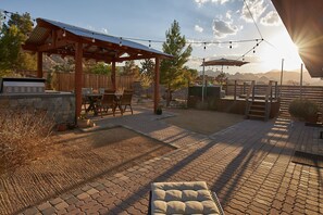 A patio with a pergola, outdoor furniture, and string lights.