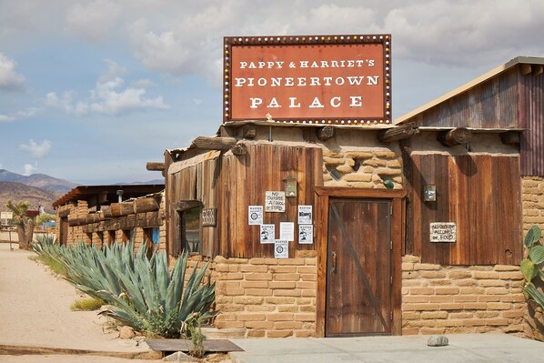 Un edificio rustico con un cartello che riporta 'Pappy & Harriet's Pioneer Town Palace'.