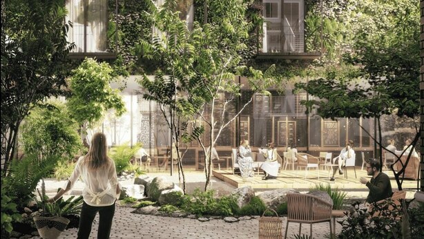 A courtyard with seating areas, greenery, and a building with large windows. - Hotel & Restaurant heyligenstaedt (Giessen)