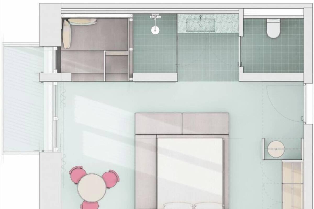 A bedroom with a bed, bedside tables, and a small round table with chairs.