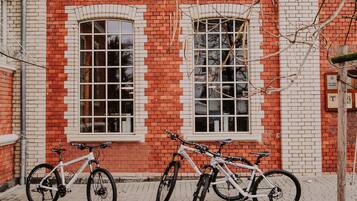 A red brick building with three bicycles parked in front.