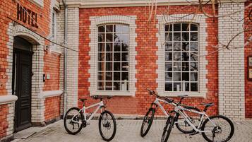 A red brick building with two bicycles parked in front.