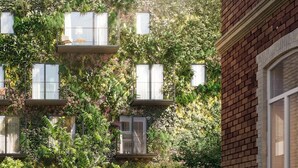A building with multiple windows, some with balconies, surrounded by lush greenery and plants. - Hotel & Restaurant heyligenstaedt (Giessen)