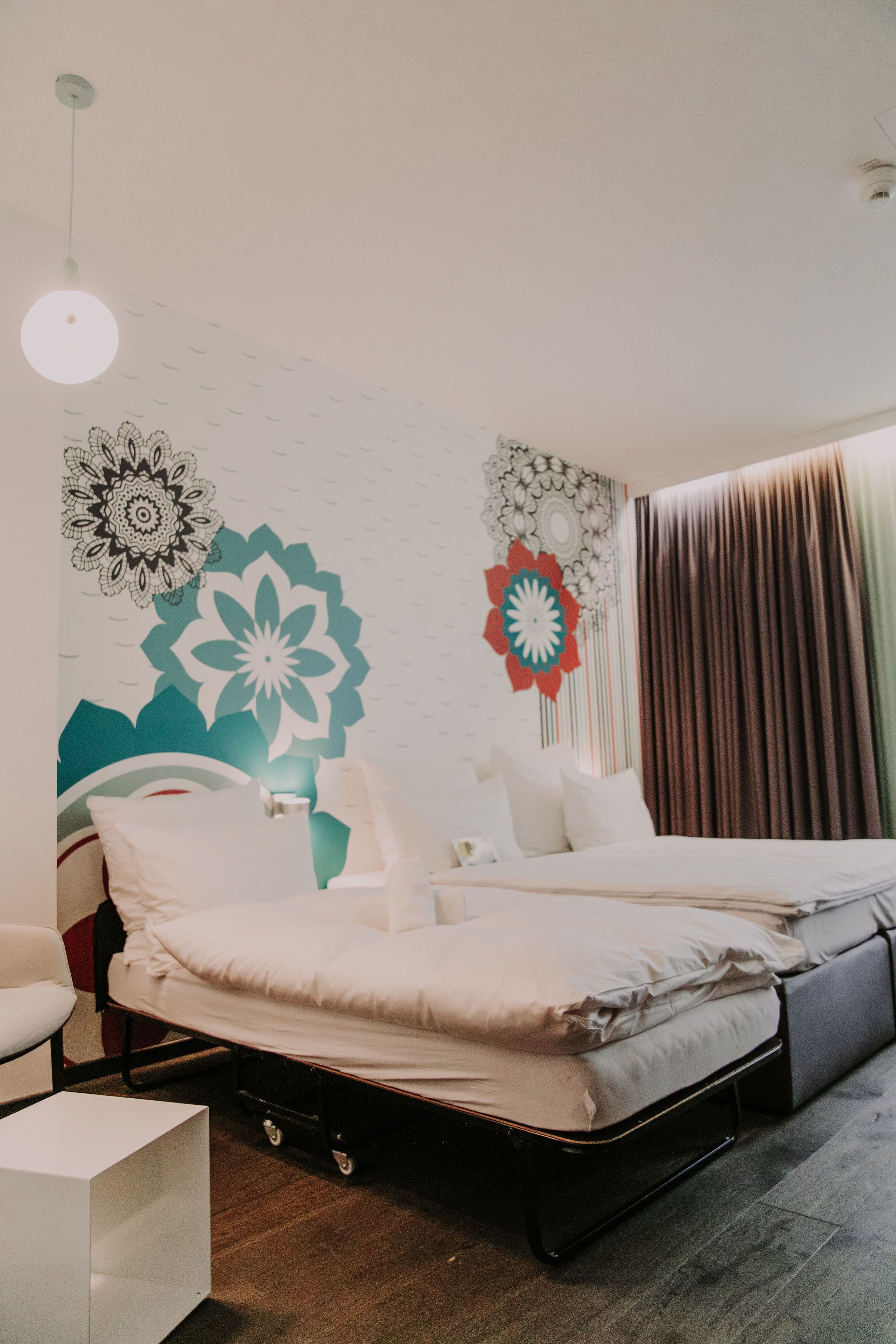 A modern bedroom with a bed, bedside tables, and decorative wall art.