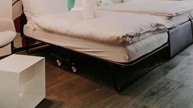 Un dormitorio moderno con cama, mesitas de noche y decoración mural.