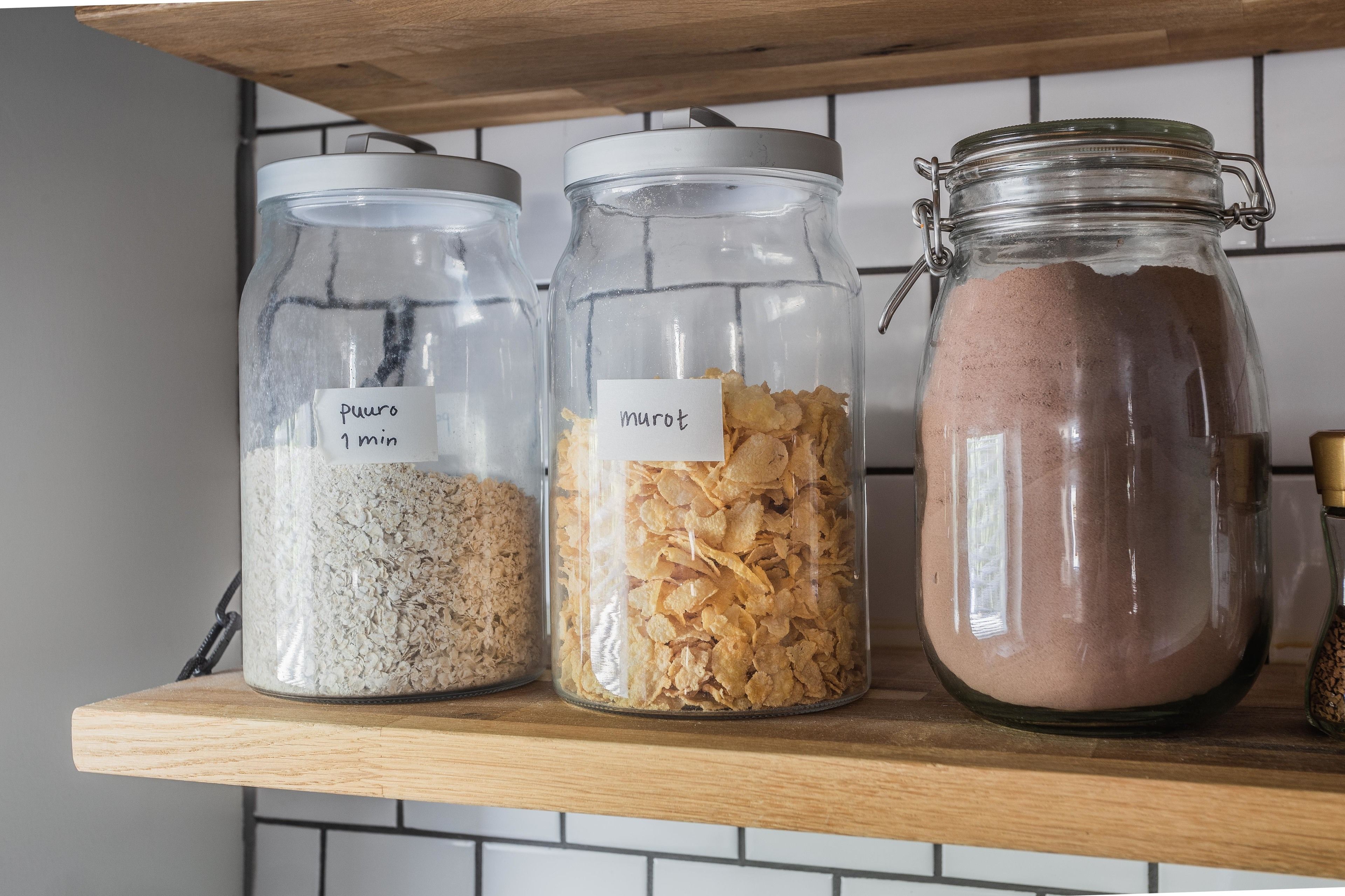 Three glass jars on a wooden shelf, each labeled with a different ingredient.